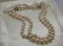 Picture of 26 INCH LONG  PEARL PEACH COLOR (7MM)  NECKLACE WITH 14KT WHITE GOLD CLASP VERY GOOD CONDITION. WITH CASE.